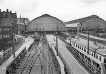 849029 Gezicht op de perrons aan de oostzijde buiten de kap van het N.S.-station Amsterdam C.S. te Amsterdam.